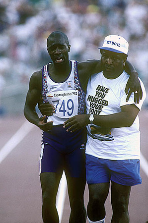Barcelona, Spain:
British runner Derek Redmond a medal favorite is helped across the finish line by his father who ran down from the stands when his son pulled a muscle in his qualifying heat at the Olympics.